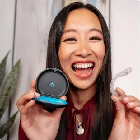 woman smiling holding aligners and case